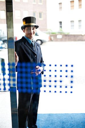porteiro - Hotel doorman at your service. Buildings and cars in the background Foto de stock - Royalty-Free Super Valor e Assinatura, Número: 400-08185217