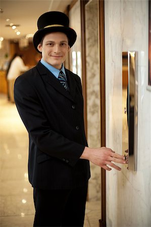 Profile shot of a doorman in a bowler hat waiting near the elevators Stock Photo - Budget Royalty-Free & Subscription, Code: 400-08185220