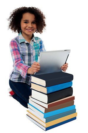 school kneeling - Active smiling school girl kneeling near pile of books, holding tablet pc Stock Photo - Budget Royalty-Free & Subscription, Code: 400-08186660