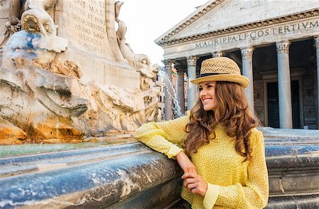 piazza della rotonda - In the background, Rome's Pantheon. In the foreground, a smiling, happy brunette looking into the distance is leaning casually on the Pantheon fountain. Stockbilder - Microstock & Abonnement, Bildnummer: 400-08189796