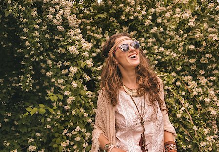 simsearch:400-08194027,k - Longhaired hippy-looking young lady in knitted shawl and white blouse standing among flowers and looking up on copy space Photographie de stock - Aubaine LD & Abonnement, Code: 400-08194027