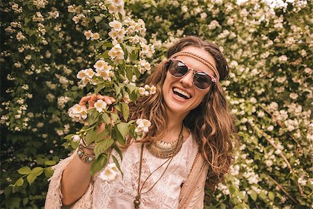 Longhaired hippy-looking young lady in knitted shawl and white blouse standing among flowers Stock Photo - Budget Royalty-Free & Subscription, Code: 400-08194023