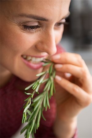 rosemary sprig - A woman smiles as she takes a little nip of some fresh rosemary. Impossible to resist the rich, earthy flavour of freshly-picked rosemary. The hard part will be deciding which dish to cook... Stock Photo - Budget Royalty-Free & Subscription, Code: 400-08195139