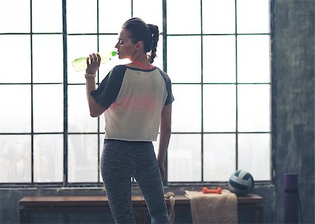 simsearch:400-08189778,k - Fit woman in workout gear in profile drinking from water bottle in a loft gym in the city. Foto de stock - Super Valor sin royalties y Suscripción, Código: 400-08195145