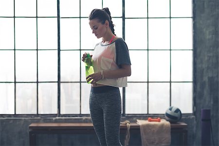 simsearch:400-08189778,k - Putting the lid back on to her water bottle, a woman looks down at what she is doing. A good drink after a long workout is so refreshing. Foto de stock - Super Valor sin royalties y Suscripción, Código: 400-08195141