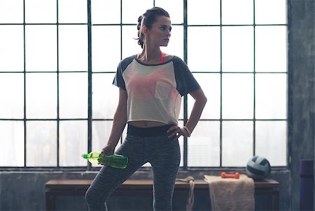 simsearch:400-08189778,k - A woman stands relaxing, looking off to the side, holding a water bottle in a loft gym after a good workout. Foto de stock - Super Valor sin royalties y Suscripción, Código: 400-08195142