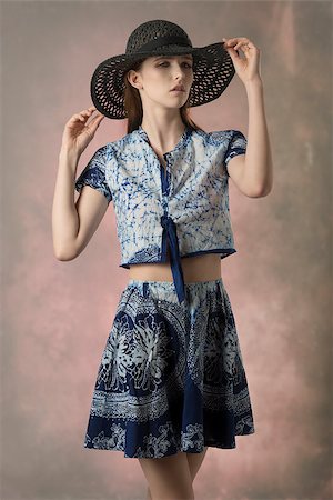 simsearch:400-08890472,k - cute young brunette model in fashion pose with black hat and blue printed top and skirt, trendy spring summer outfit Stockbilder - Microstock & Abonnement, Bildnummer: 400-08197237