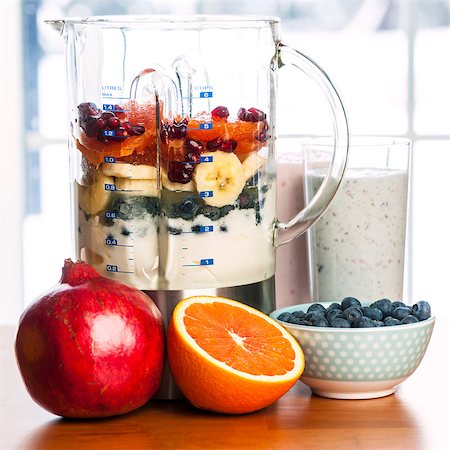 photos of blueberries for kitchen - Prepared smoothies and healthy smoothie ingredients in blender with fresh fruit ready to blend on kitchen table Foto de stock - Super Valor sin royalties y Suscripción, Código: 400-08197377
