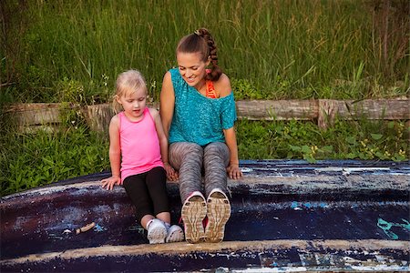 Deep in conversation, a young mother is sitting with her daughter on an upturned boat. Imagine the seaside adventure stories they are inventing... Stock Photo - Budget Royalty-Free & Subscription, Code: 400-08198087
