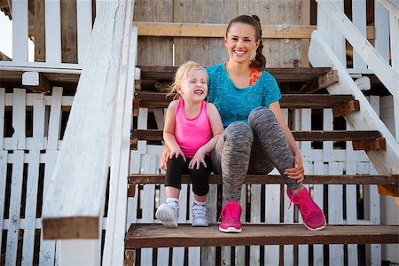 shack child - A happy young mother is sitting with her young daughter on the steps of a beach-front house. They are both wearing fitness gear, and are about to go run and play on the beach. Stock Photo - Budget Royalty-Free & Subscription, Code: 400-08198082