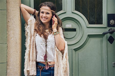 simsearch:400-08194027,k - Happy woman wearing bohemian style clothes standing outside buildings in street and talking cell phone Photographie de stock - Aubaine LD & Abonnement, Code: 400-08198996