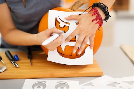 simsearch:400-07172678,k - Closeup on woman using stencils to carve big orange pumpkin Jack-O-Lantern for Halloween party. Traditional autumn holiday Photographie de stock - Aubaine LD & Abonnement, Code: 400-08199662