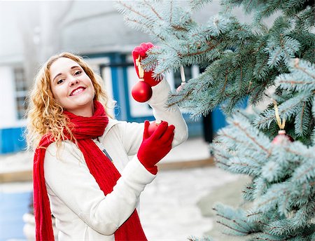 Joyful woman hanging Christmas ornaments on spruce tree outdoors in yard near home Stock Photo - Budget Royalty-Free & Subscription, Code: 400-08199815