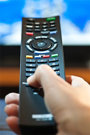 simsearch:400-05223721,k - Hand holding television remote control pressing buttons Foto de stock - Royalty-Free Super Valor e Assinatura, Número: 400-08224009