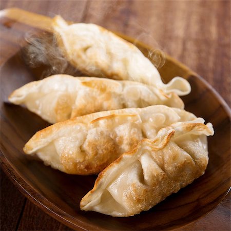 simsearch:400-08225258,k - Fresh pan fried dumplings on plate with hot steams. Asian dish on rustic old vintage wooden background. Foto de stock - Super Valor sin royalties y Suscripción, Código: 400-08224989