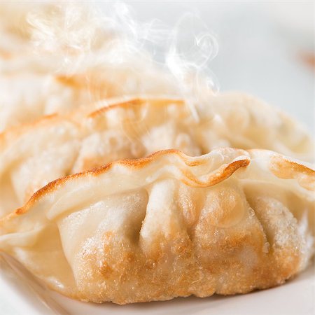 simsearch:400-08225258,k - Close up fresh pan fried dumplings on plate with hot steams. Asian food on rustic vintage wooden background. Foto de stock - Super Valor sin royalties y Suscripción, Código: 400-08224992