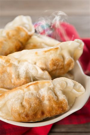 simsearch:400-08225258,k - Fresh pan fried dumplings on bowl with hot steams. Asian meal on rustic vintage wooden background. Foto de stock - Super Valor sin royalties y Suscripción, Código: 400-08225247