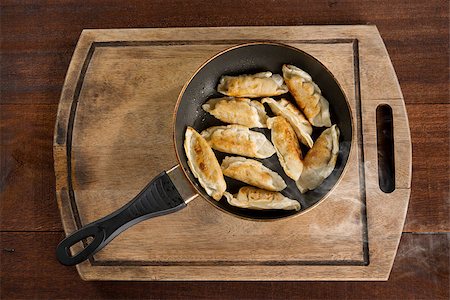 simsearch:400-08225258,k - Top view cooking fried dumplings in a frying pan. Chinese food with hot steams, on rustic vintage wooden background. Foto de stock - Super Valor sin royalties y Suscripción, Código: 400-08225265