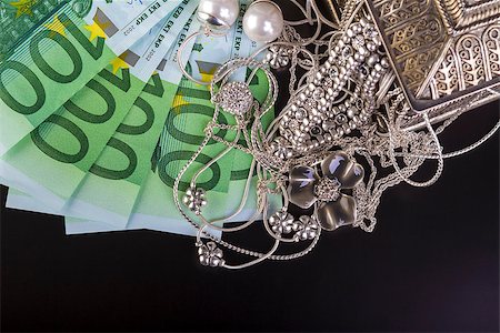 schmuckkästchen - Silver jewelry and euro on black background. Stockbilder - Microstock & Abonnement, Bildnummer: 400-08221441