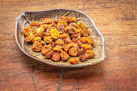 simsearch:400-08339445,k - dried goldenberries in a ceramic leaf shaped bowl against rustic scratched wood Photographie de stock - Aubaine LD & Abonnement, Code: 400-08222499