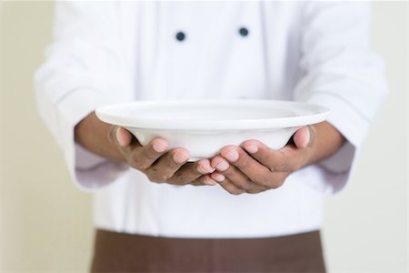 plain plate - Black male chef in uniform presenting an empty dish Stock Photo - Budget Royalty-Free & Subscription, Code: 400-08223486