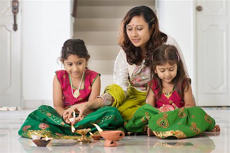 simsearch:400-08223620,k - Indian family in traditional sari lighting oil lamp and celebrating Diwali, fesitval of lights at home. Stock Photo - Budget Royalty-Free & Subscription, Code: 400-08223604