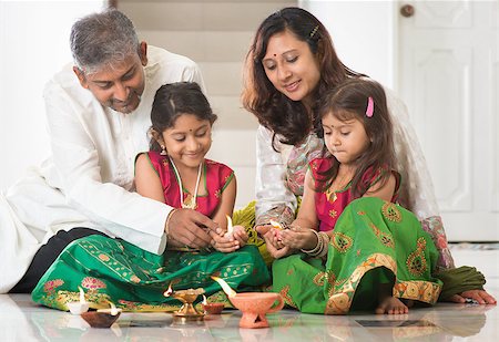 simsearch:400-08223620,k - Indian family in traditional sari lighting oil lamp and celebrating Diwali, fesitval of lights at home. Little girl hands holding oil lamp indoors. Stock Photo - Budget Royalty-Free & Subscription, Code: 400-08223607