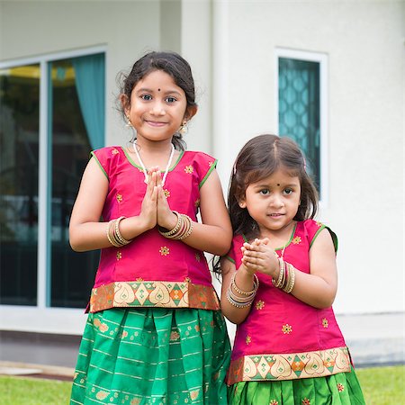 simsearch:400-08223620,k - Cute Indian girls dressed in sari with folded hands representing traditional Indian greeting, standing outside their new house celebrating diwali, festival of lights. Stock Photo - Budget Royalty-Free & Subscription, Code: 400-08223619