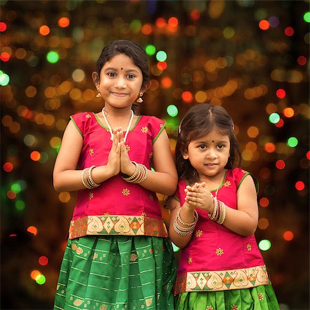 simsearch:400-08223620,k - Cute Indian girls dressed in sari with folded hands representing traditional Indian greeting, standing inside a temple celebrating diwali, festival of lights. Stock Photo - Budget Royalty-Free & Subscription, Code: 400-08223620