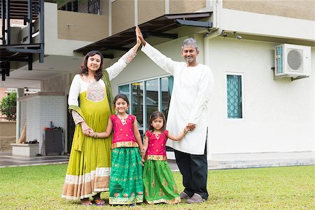 Parents forming house roof shape above children. Beautiful Asian Indian family portrait smiling and standing outside their new house. Stock Photo - Budget Royalty-Free & Subscription, Code: 400-08223623