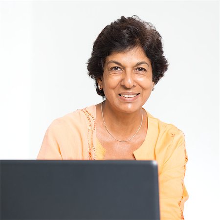 Elder people and modern technology concept. Portrait of a 50s Indian mature woman using internet at home. Indoor senior people living lifestyle. Stock Photo - Budget Royalty-Free & Subscription, Code: 400-08223684