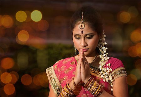 simsearch:400-08223620,k - Indian female in traditional sari praying and celebrating Diwali or deepavali, fesitval of lights at temple. Girl prayer hands folded, beautiful lights bokeh background. Stock Photo - Budget Royalty-Free & Subscription, Code: 400-08223693