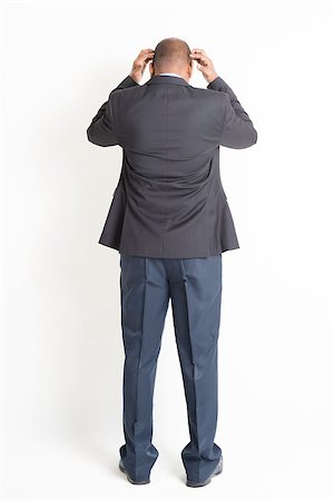 Rear view full body mature Indian business man hands scratching head and running out of idea , standing on plain background. Stock Photo - Budget Royalty-Free & Subscription, Code: 400-08223788