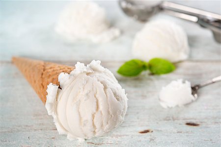 simsearch:400-08225242,k - Scoop vanilla ice cream in waffle cone with utensil on wood background. Stockbilder - Microstock & Abonnement, Bildnummer: 400-08223852