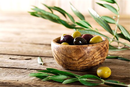 simsearch:400-05666507,k - olives on olive branch. Wooden table with olives in bowl Stock Photo - Budget Royalty-Free & Subscription, Code: 400-08254076