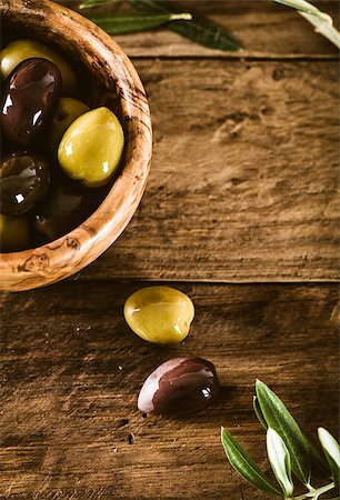 simsearch:400-05666507,k - olives on olive branch. Wooden table with olives in bowl Stock Photo - Budget Royalty-Free & Subscription, Code: 400-08254544