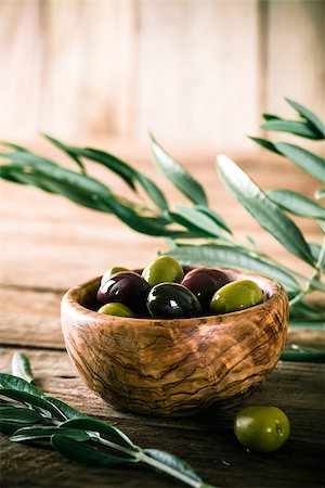 simsearch:400-05666507,k - olives on olive branch. Wooden table with olives in bowl Stock Photo - Budget Royalty-Free & Subscription, Code: 400-08254541