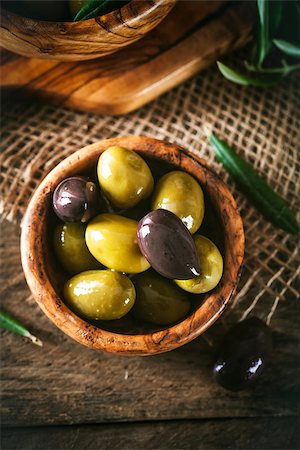 simsearch:400-05666507,k - olives on olive branch. Wooden table with olives in bowl Stock Photo - Budget Royalty-Free & Subscription, Code: 400-08254542