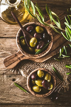 simsearch:400-05666507,k - olives on olive branch. Wooden table with olives in bowl Stock Photo - Budget Royalty-Free & Subscription, Code: 400-08254543