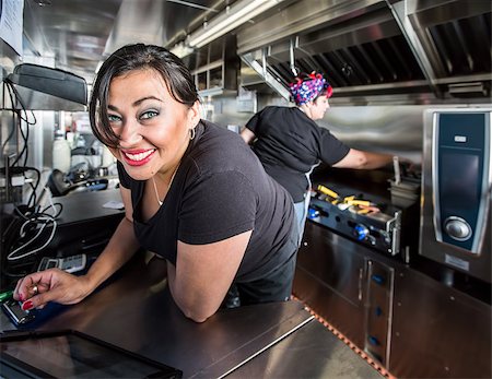 Dark haired smiling cashier with blue eyes on food truck Stock Photo - Budget Royalty-Free & Subscription, Code: 400-08254694