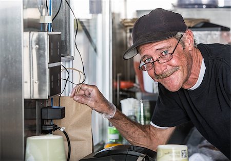 restaurant male cashier - Smiling worker with order from inside food truck Stock Photo - Budget Royalty-Free & Subscription, Code: 400-08254696