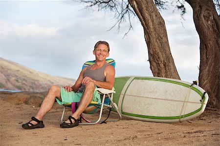 Single cheerful athletic male sitting with surfboard Stock Photo - Budget Royalty-Free & Subscription, Code: 400-08254690