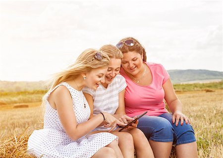 Group of friends outdoors in a field with a tablet Stock Photo - Budget Royalty-Free & Subscription, Code: 400-08254820