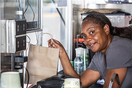 Smiling African-American worker hands order out window of modern food truck Stock Photo - Budget Royalty-Free & Subscription, Code: 400-08254984