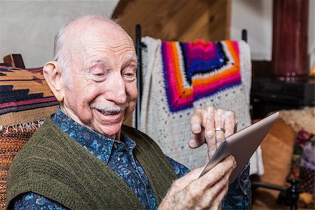 simsearch:400-04065514,k - Smiling older gentleman working on a tablet in his living-room Foto de stock - Super Valor sin royalties y Suscripción, Código: 400-08255004