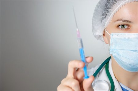 Female doctor with syringe, focus on eyes Stock Photo - Budget Royalty-Free & Subscription, Code: 400-08255038