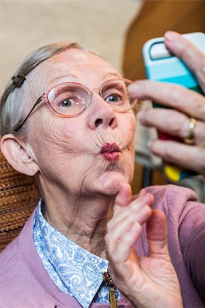 picture of woman with old mobile phone - Happy elder woman taking duck face selfie Stock Photo - Budget Royalty-Free & Subscription, Code: 400-08255872