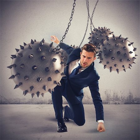Businessman between fierce spiky balls that hinder Stock Photo - Budget Royalty-Free & Subscription, Code: 400-08256538