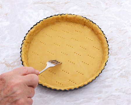 simsearch:400-06693299,k - Woman finishes pricking holes in a shortcrust pastry pie crust for blind baking Stockbilder - Microstock & Abonnement, Bildnummer: 400-08256608