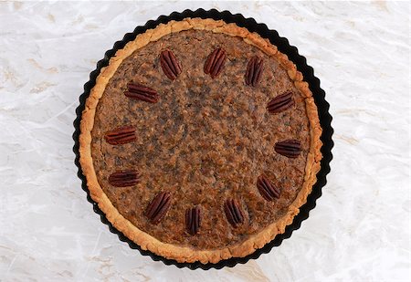 pecan pie - Pecan pie fresh from the oven on a marbled kitchen work surface Stock Photo - Budget Royalty-Free & Subscription, Code: 400-08256610